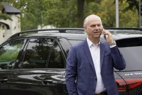 Nils Brennecke telefoniert vor einem Mercedes GLE
