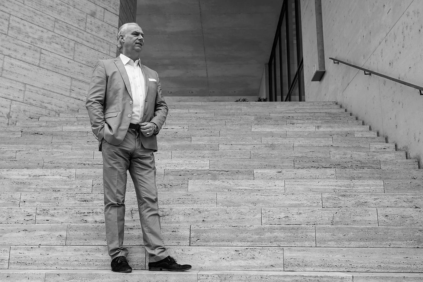 Nils Brennecke vor einer modernen Architektur mit breiter Treppe